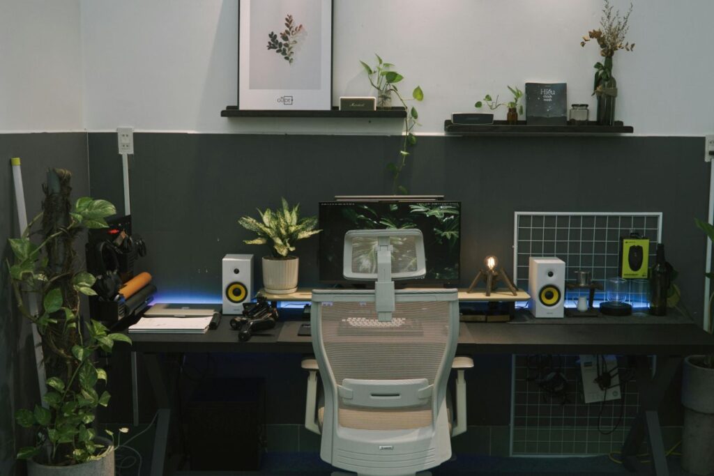 A modern ergonomic home office setup with a mesh desk chair, organized black desk, and soft ambient lighting to reduce eye strain.