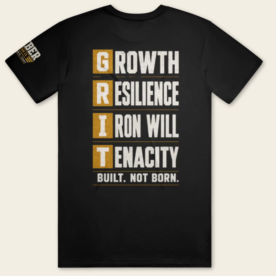Back view of the BUILD GRIT Premium T-Shirt in Graphite Black featuring the GRIT acronym design with Growth, Resilience, Iron Will, and Tenacity.