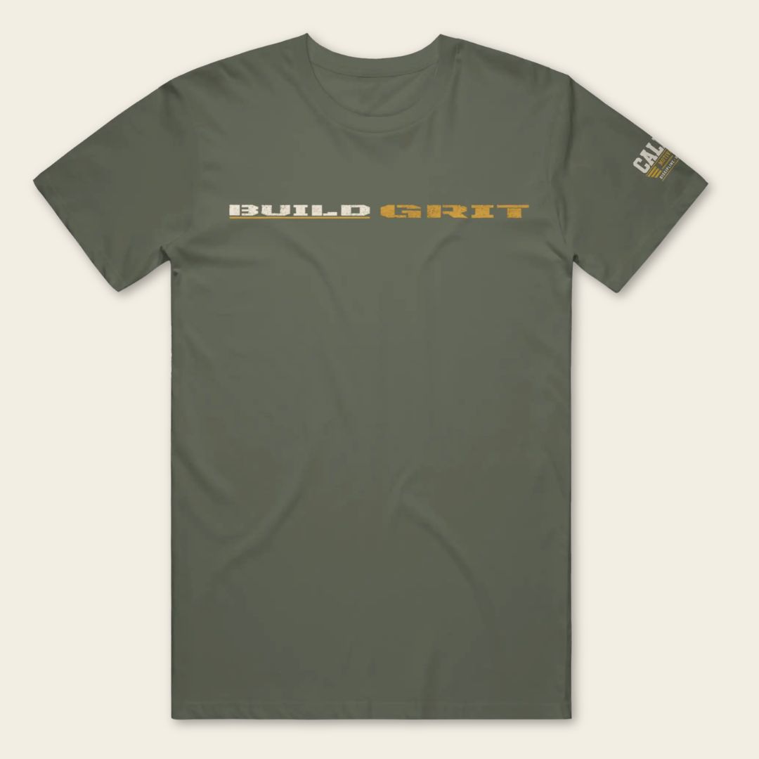 Front view of the BUILD GRIT Premium T-Shirt in Military Green featuring distressed BUILD GRIT artwork and a Caliber Motivation Co. sleeve patch.