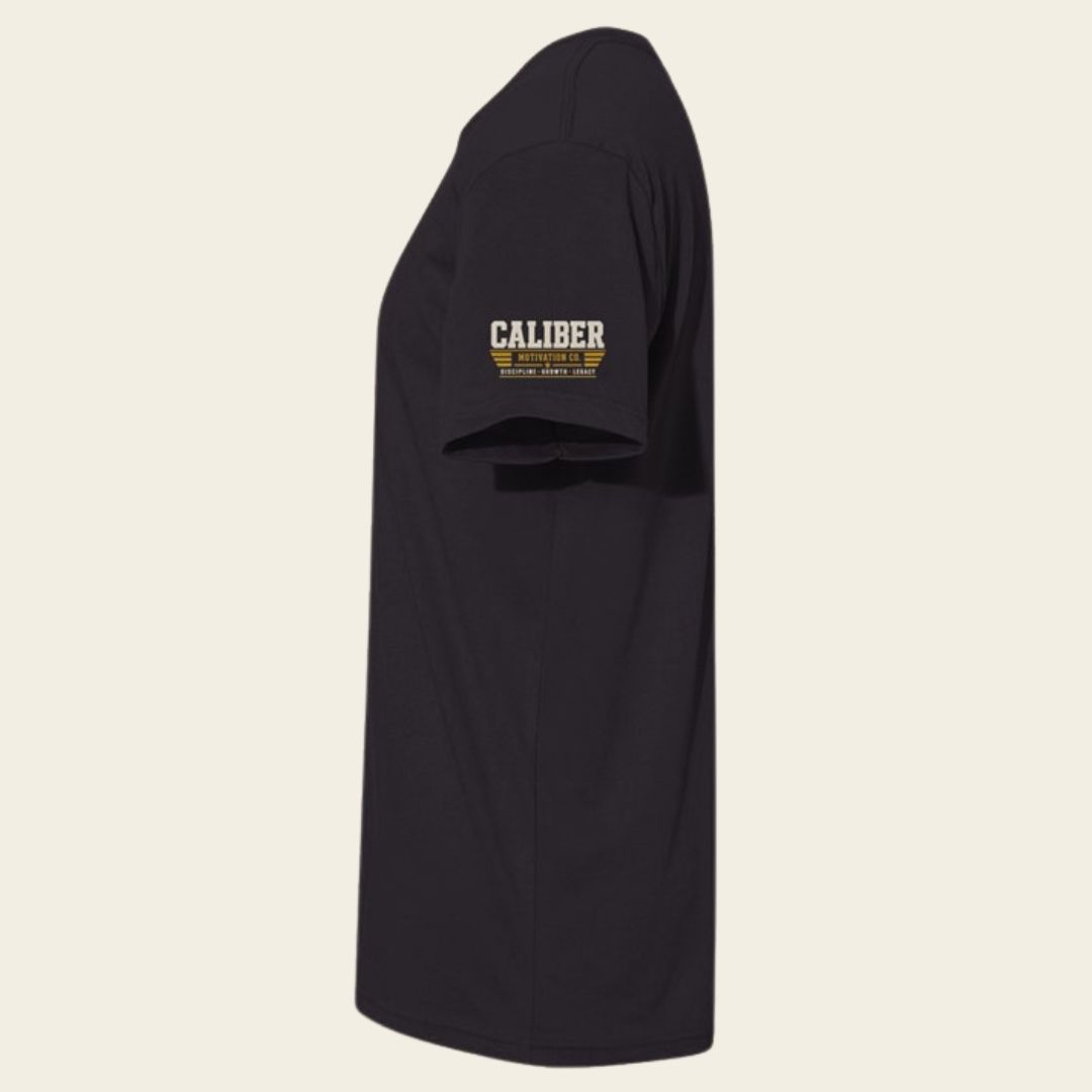 Close-up of the embroidered-look Caliber Motivation Co. sleeve graphic on the BUILD GRIT Premium T-Shirt.