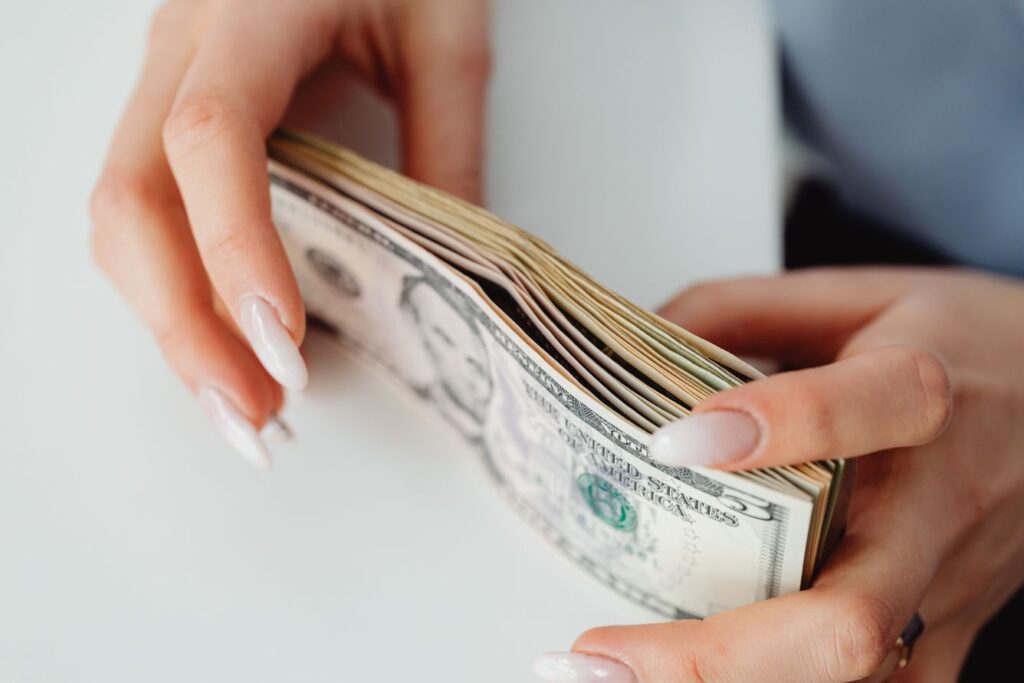 Person counting cash while learning wealth-building principles from The Psychology of Money