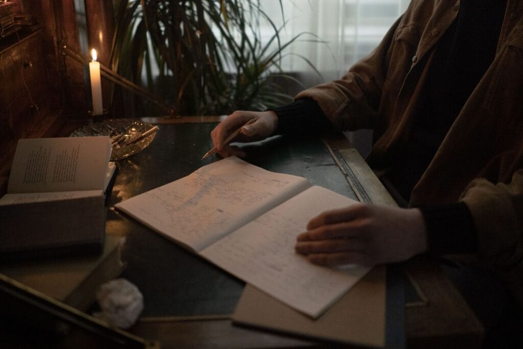 Person writing goals in a notebook while applying Bob Proctor lessons on mindset and personal growth