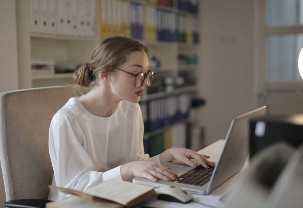 Niche digital products creator working on a laptop while building digital assets and planning long-term business growth.