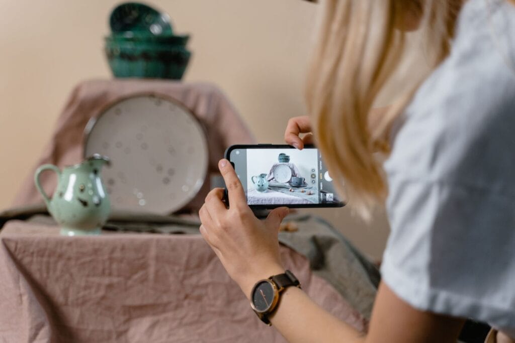 Woman photographing handmade plates as one of the reasons to become an entrepreneur
