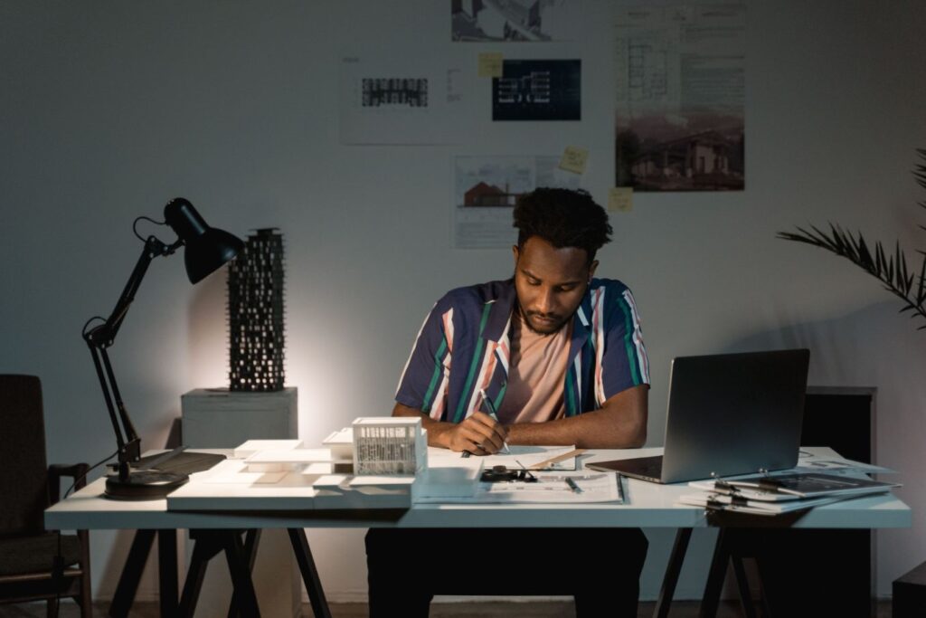 Professional working from home at a desk with a laptop and paperwork, representing a virtual assistant business.