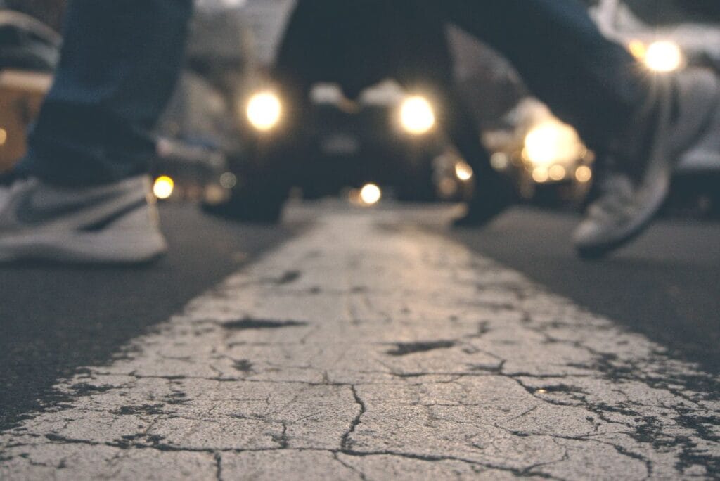 Cracked pavement beneath the feet of several people, symbolizing life's challenges and the possibility of starting over.